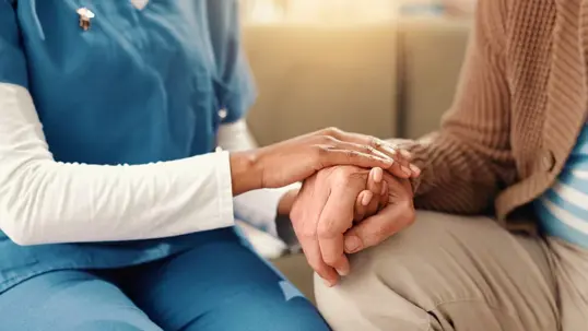 caregiver holding senior's hand